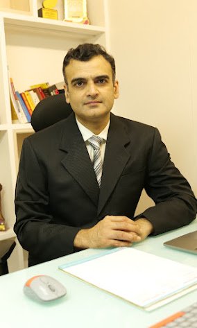 Dr Animesh Damani Plastic Surgeon in Indore sitting in clinic