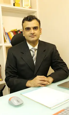 Dr Animesh Damani Plastic Surgeon in Indore sitting in clinic